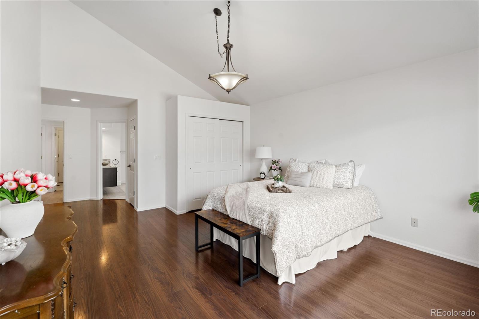 9838 Cypress Point Circle Lone Tree, CO 80124 - Photo 24 of 50 a bedroom with bed and a chandelier