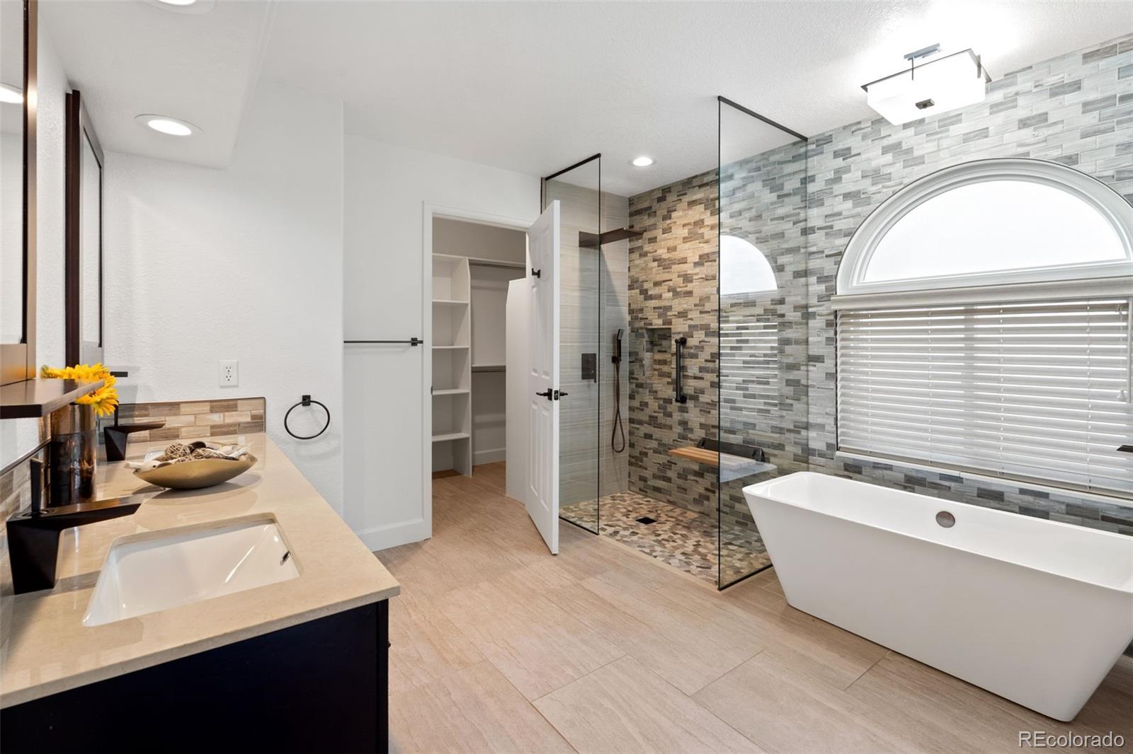 9838 Cypress Point Circle Lone Tree, CO 80124 - Photo 25 of 50 a bathroom with a bathtub sink and mirror