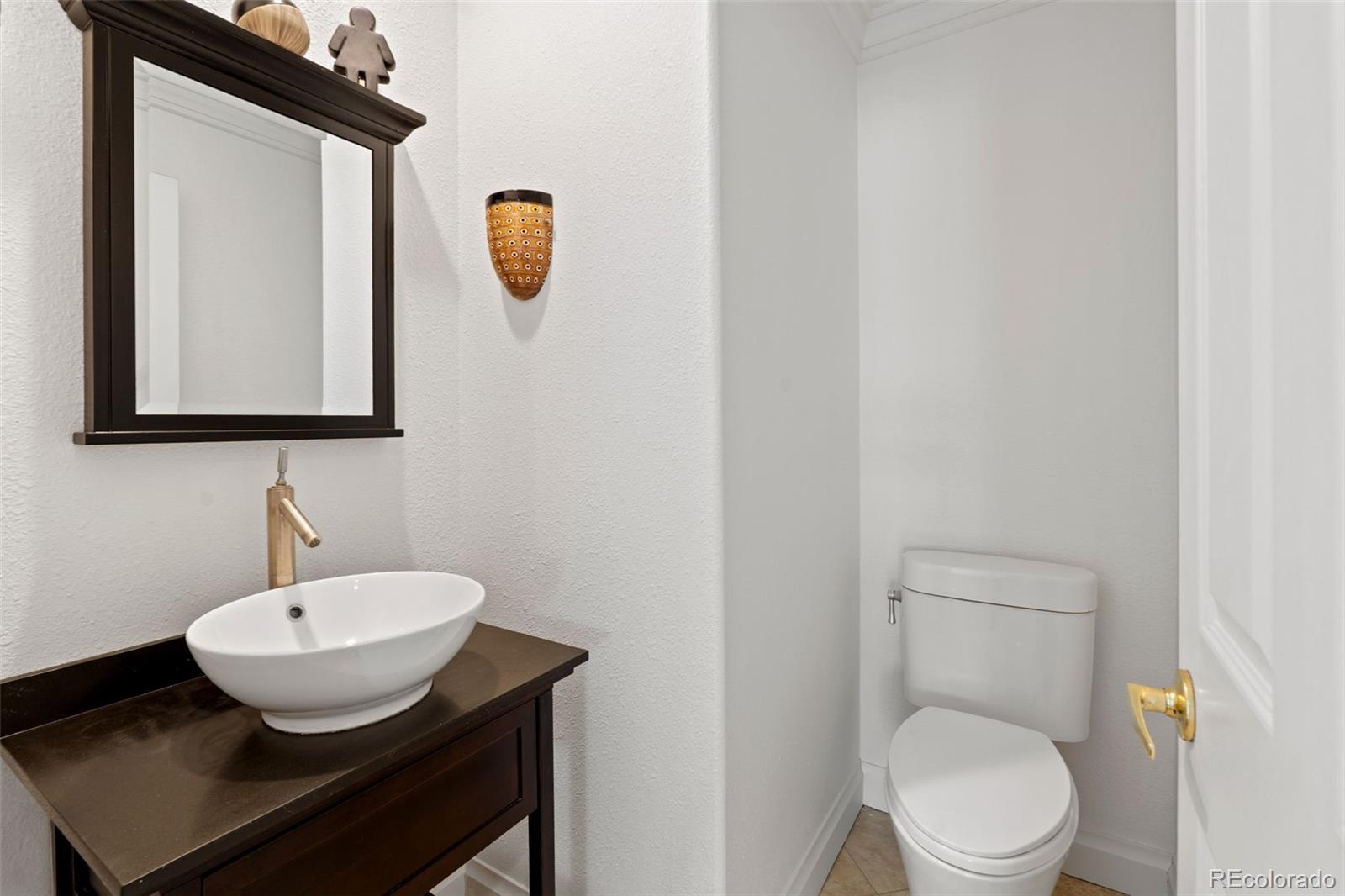 9838 Cypress Point Circle Lone Tree, CO 80124 - Photo 30 of 50 a bathroom with a toilet a sink and mirror