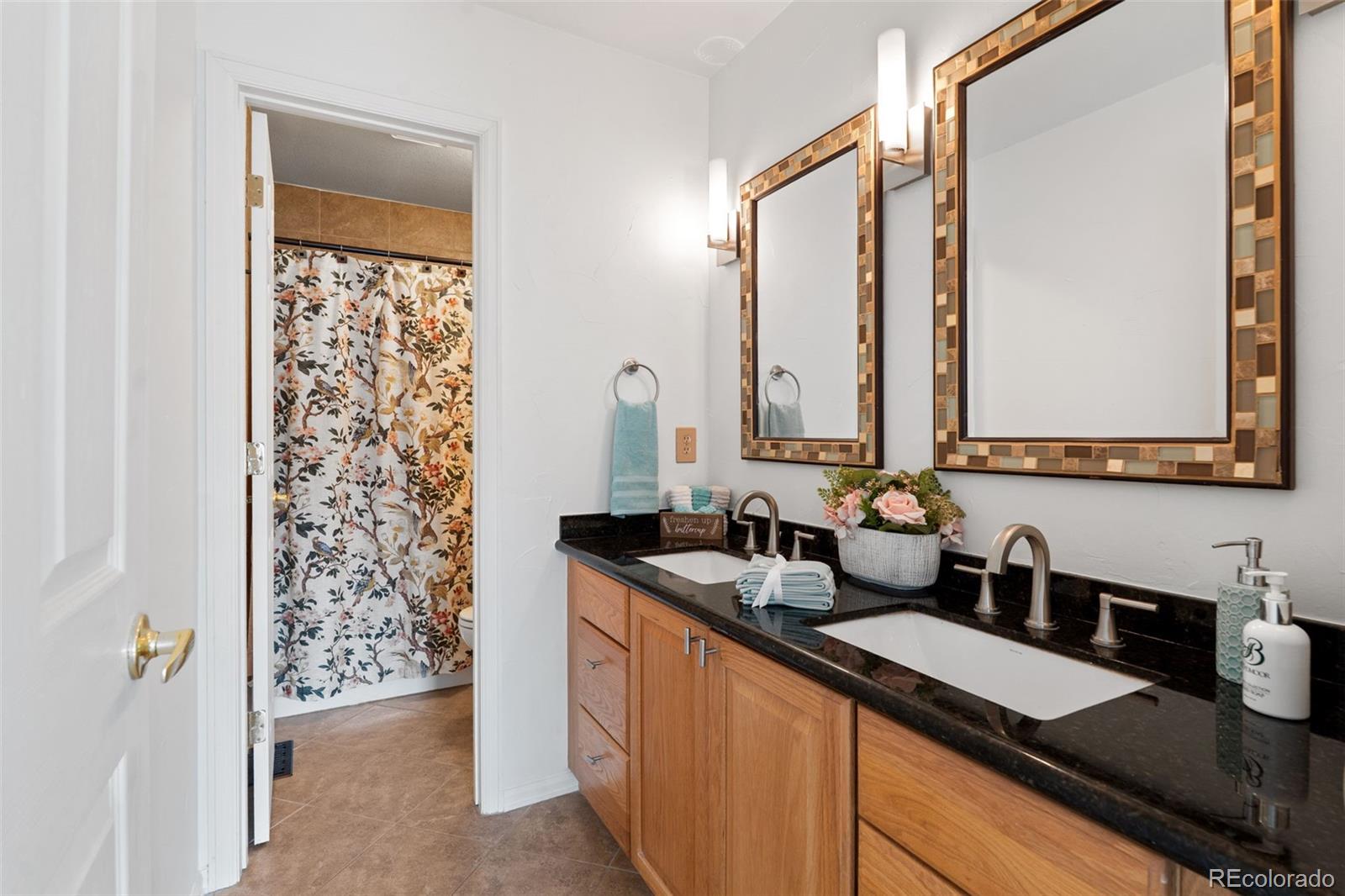 9838 Cypress Point Circle Lone Tree, CO 80124 - Photo 35 of 50 a bathroom with a granite countertop sink and a mirror