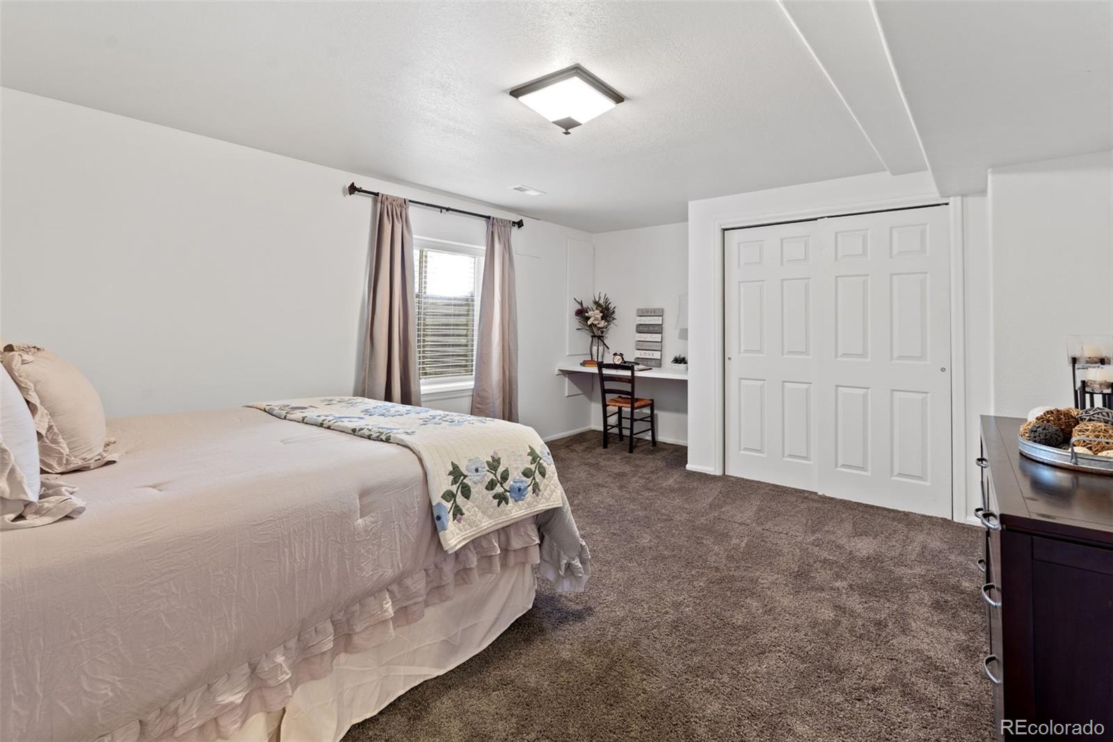 9838 Cypress Point Circle Lone Tree, CO 80124 - Photo 41 of 50 a spacious bedroom with a bed and furniture