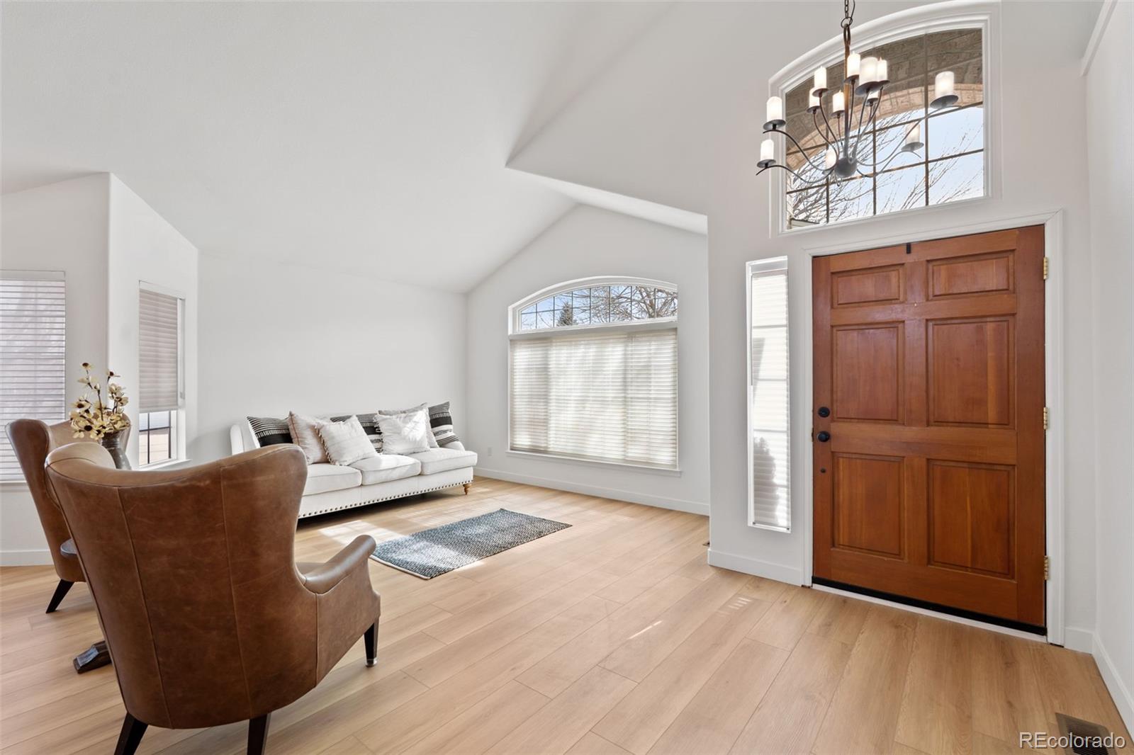 9838 Cypress Point Circle Lone Tree, CO 80124 - Photo 6 of 50 a living room with furniture a chandelier and a window