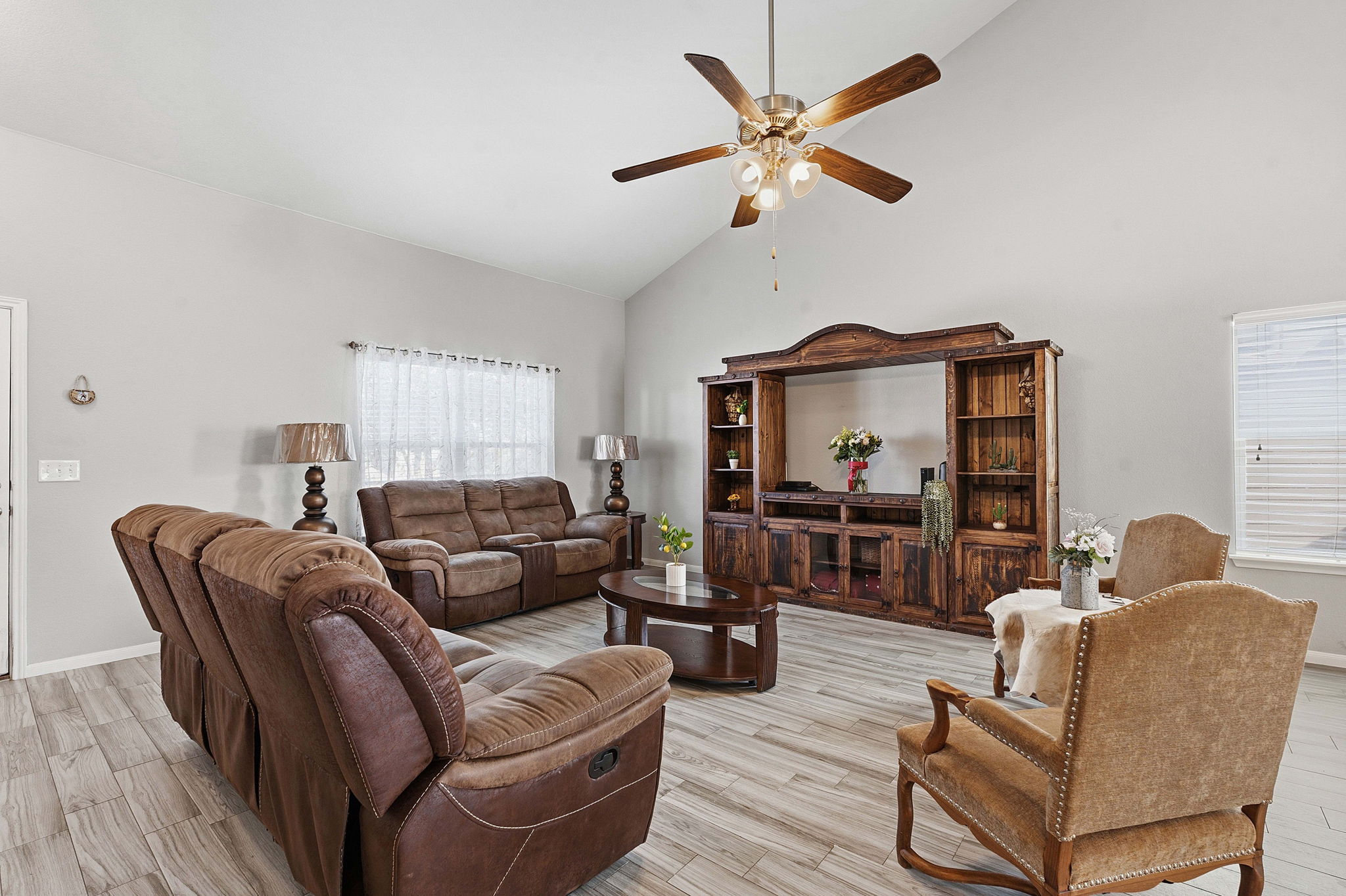 15101 Shell Bark Cove Austin, TX 78724 - Photo 5 of 26 Living area featuring a vaulted ceiling with a ceiling fan, wood-finish flooring, and a window with blinds