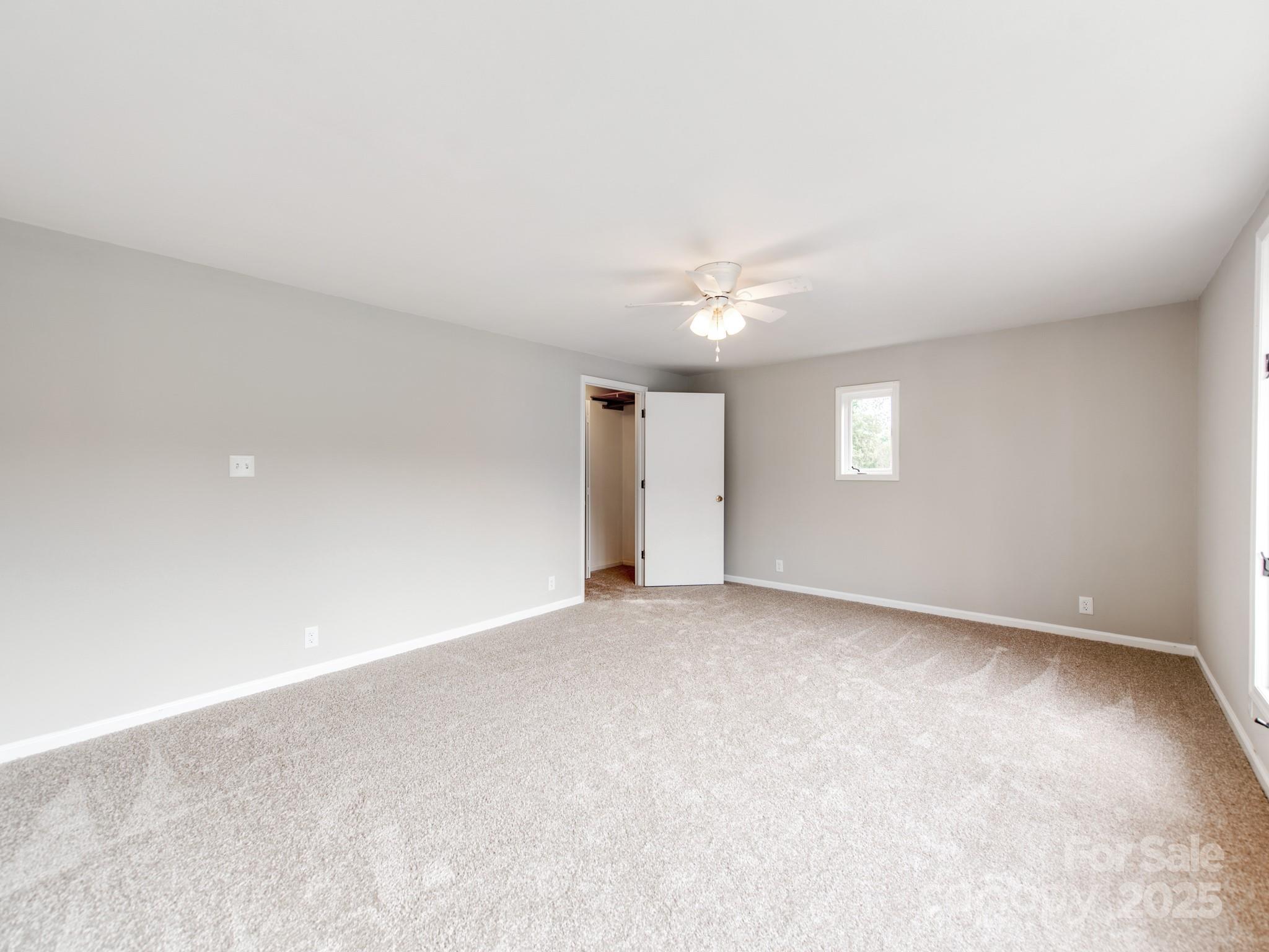 3607 Austin Road Monroe, NC 28112 - Photo 11 of 39 an empty room with windows and chandelier fan