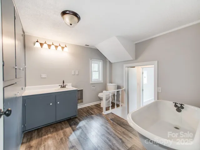 a bathroom with a tub sink and mirror