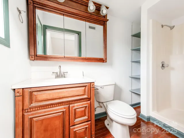 a bathroom with a toilet a sink and mirror