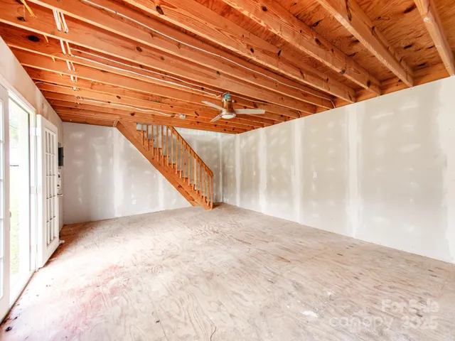 an empty room with a chandeliers and white walls