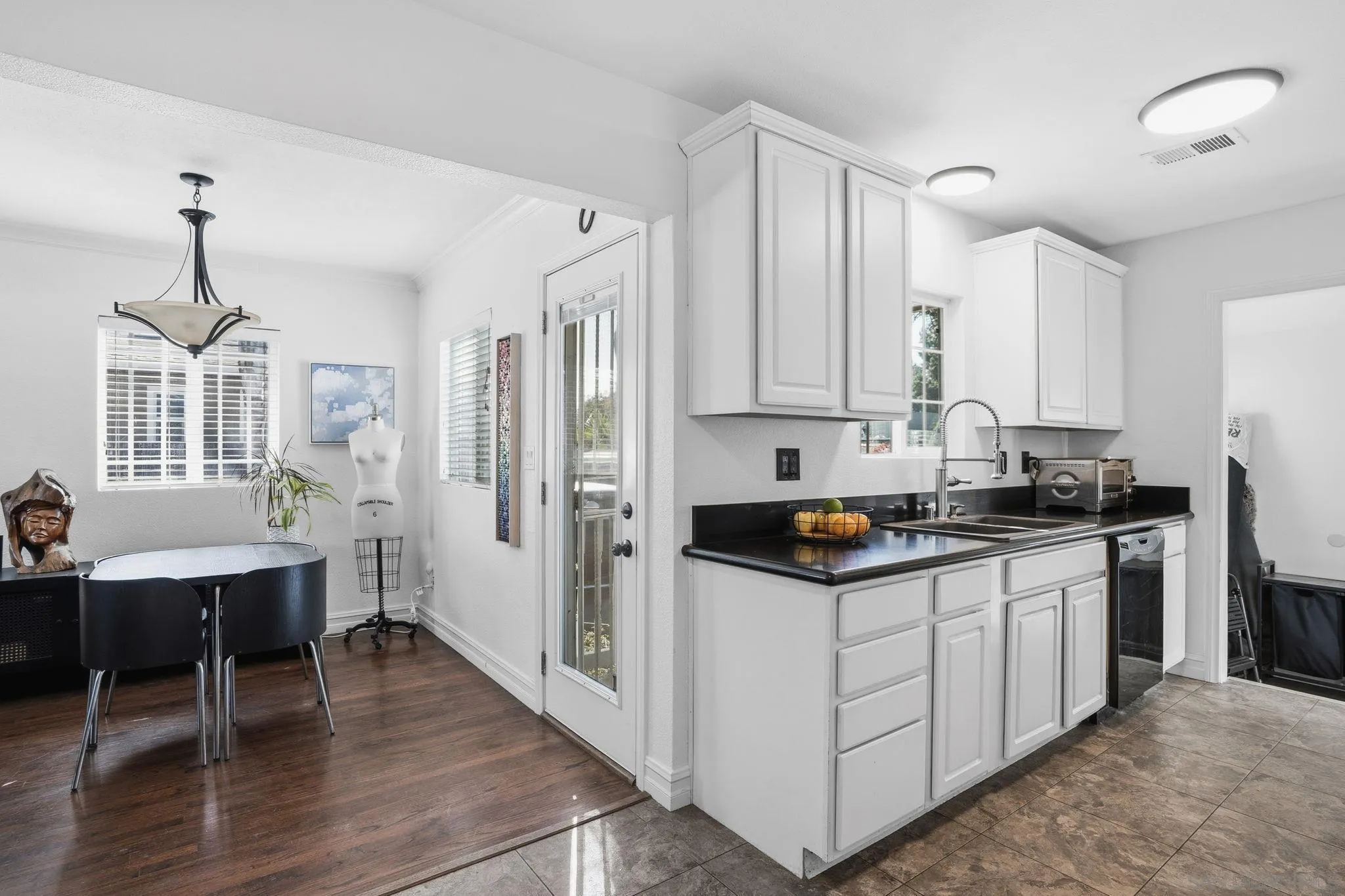 480 Orlando Street El Cajon, CA 92021 - Photo 10 of 25 a kitchen with stainless steel appliances a stove a sink dishwasher a refrigerator and white cabinets with wooden floor