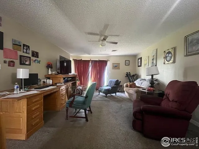 a living room with furniture a bookshelf and a window