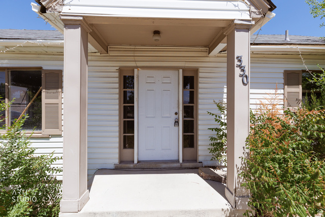 330 West 600th Street South Provo, UT 84601 - Photo 3 of 26 Front entry featuring a white paneled door with sidelights, a covered porch with square columns, and horizontal siding