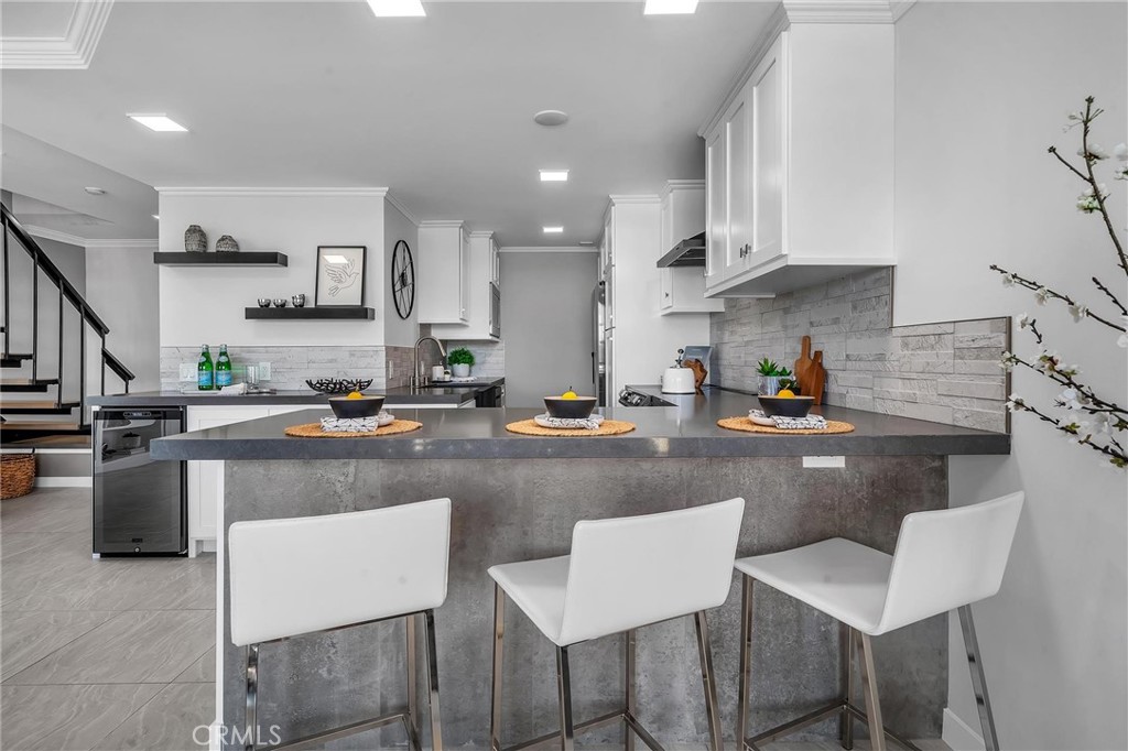 531 Esplanade, Unit 505 Redondo Beach, CA 90277 - Photo 15 of 65 a kitchen with stainless steel appliances granite countertop a table chairs sink and cabinets