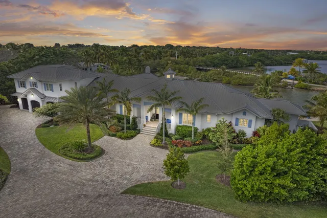 a kitchen with stainless steel appliances kitchen island granite countertop a stove a sink a dining table and chairs with wooden floor