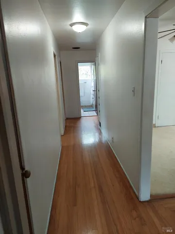 a view of hallway with wooden floor