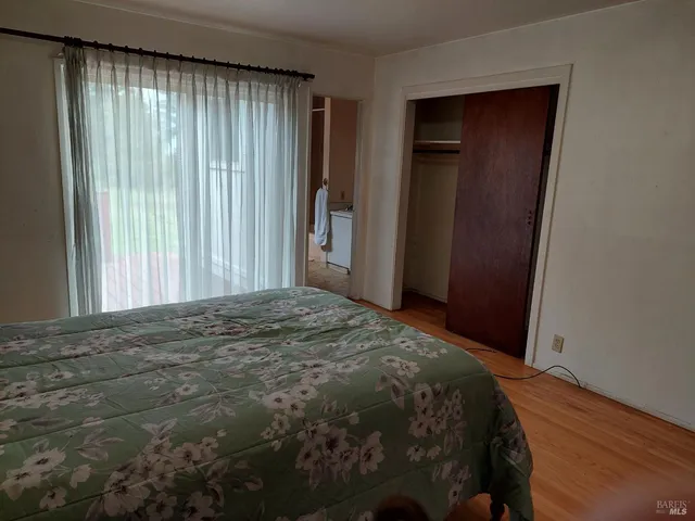 a bedroom with a bed and wooden floor