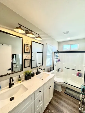 a bathroom with a double vanity sink mirror and toilet