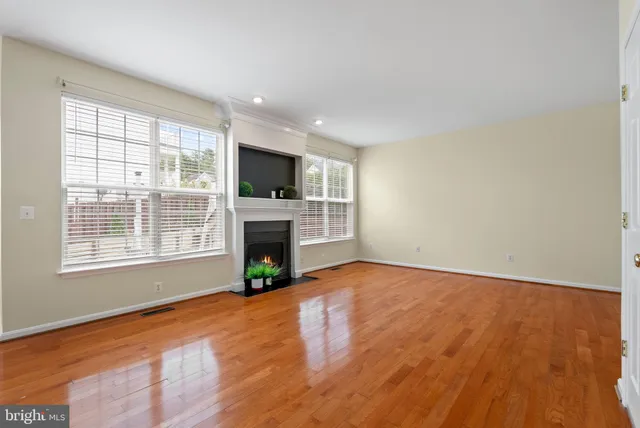 a view of empty room with a fireplace and wooden floor