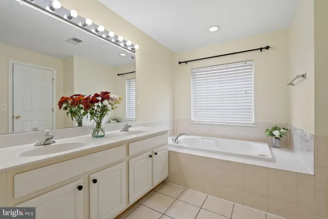 a bathroom with a tub a sink and mirror