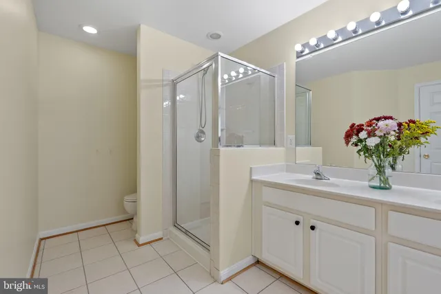 a bathroom with a double vanity sink mirror and shower