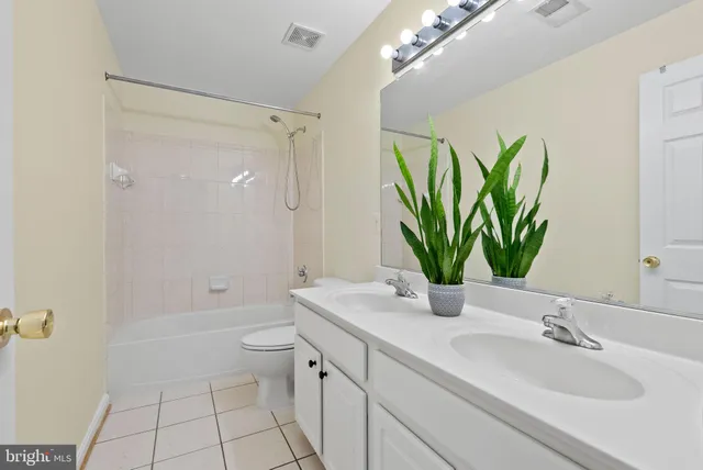 a bathroom with a granite countertop sink a toilet and shower
