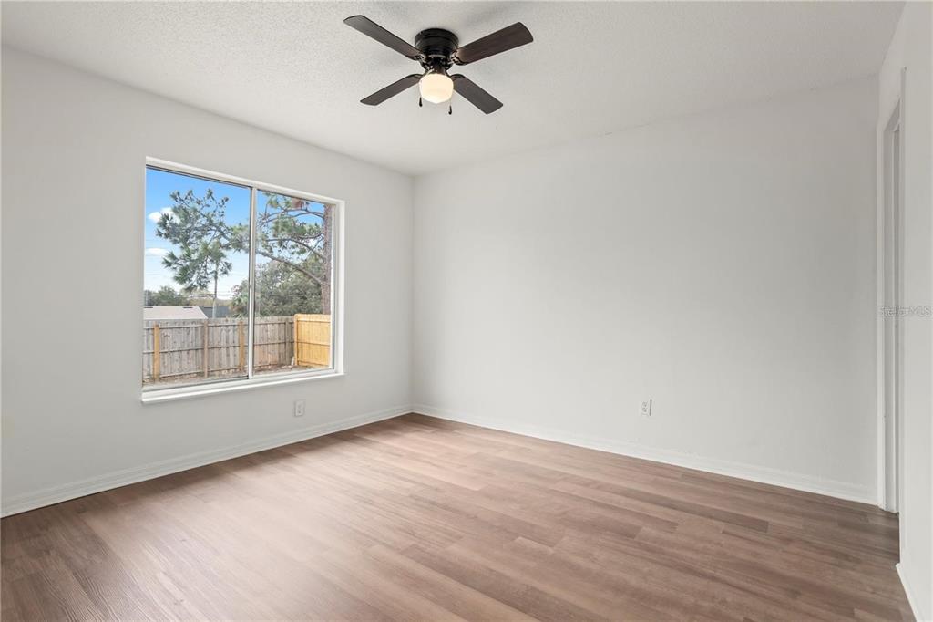 12 Winter Ridge Circle Orlando, FL 32835 - Photo 14 of 19 an empty room with wooden floor fan and windows