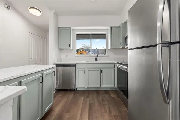 a kitchen with a sink cabinets stainless steel appliances and a window