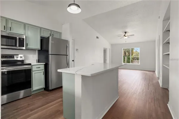 a kitchen with stainless steel appliances a refrigerator and a stove top oven