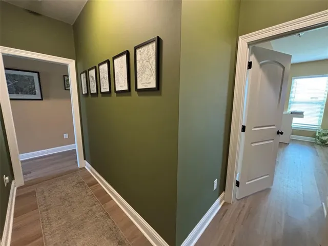 a view of a hallway with wooden floor and a living room