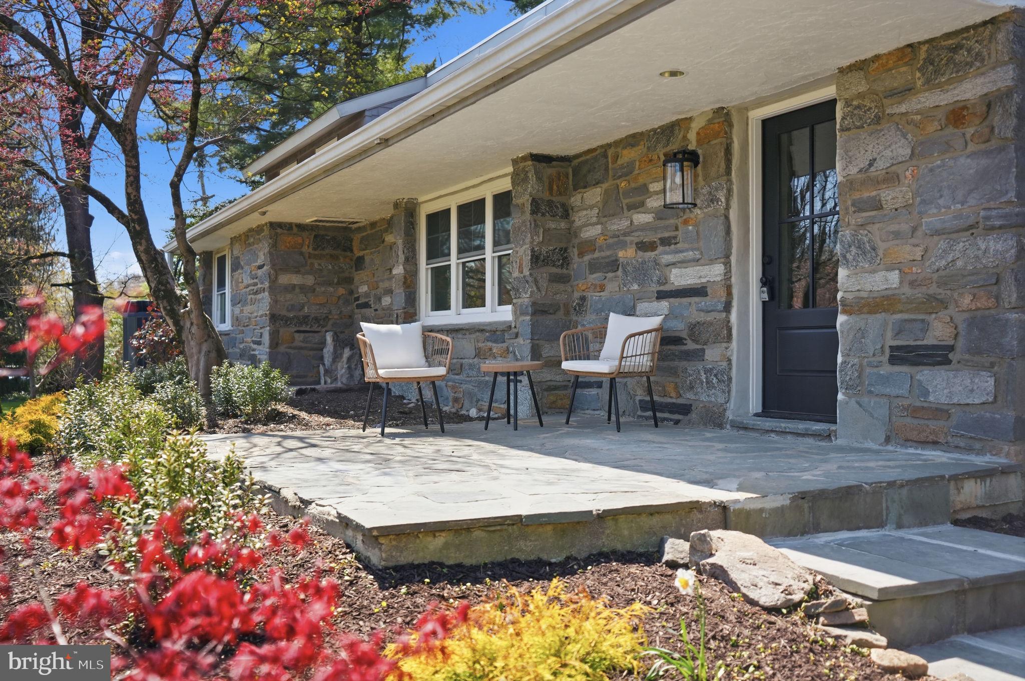 409 South Providence Road Wallingford, PA 19086 - Photo 5 of 106 Charming stone facade with vibrant blooms.