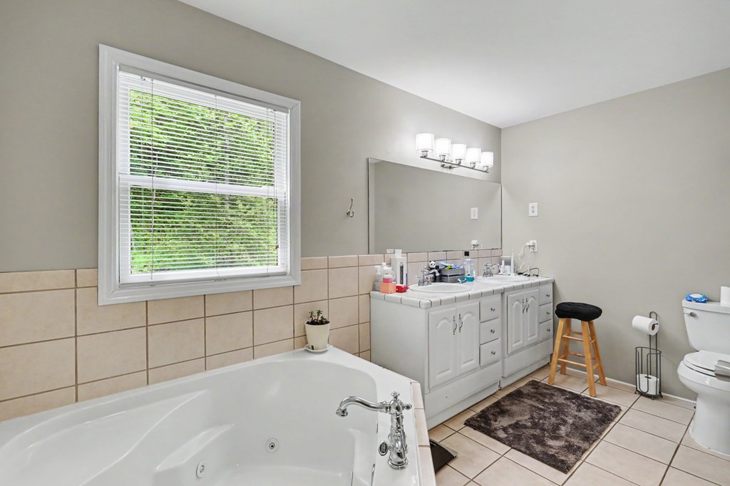 522 Fred Amos Road Murphy, NC 28906 - Photo 52 of 73 a bathroom with a bathtub a sink a window and a toilet