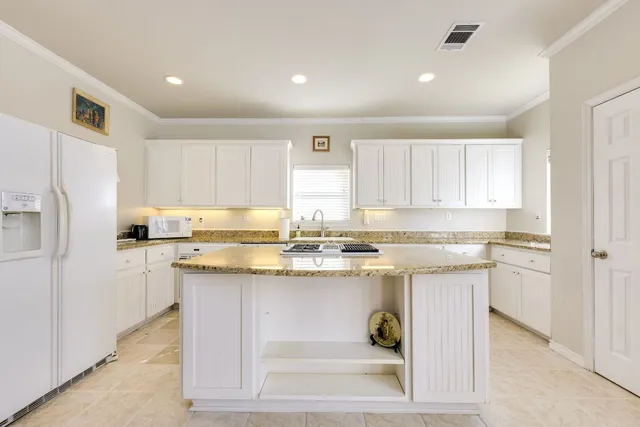 a kitchen with stainless steel appliances granite countertop a stove a sink and a refrigerator