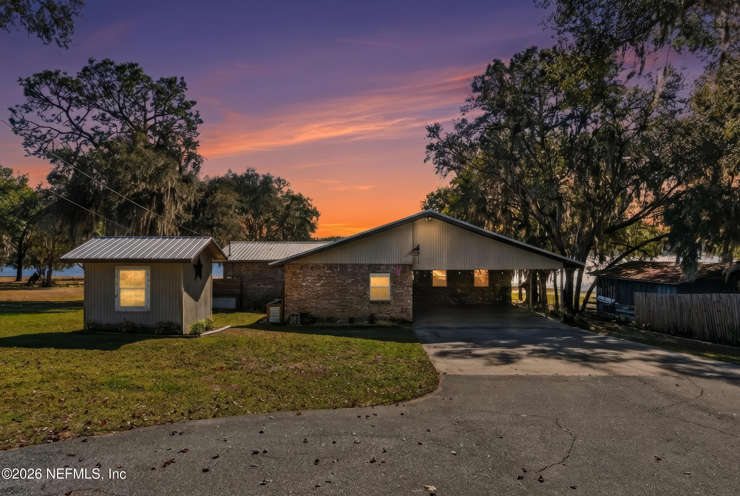228 Southeast 66th Street Starke, FL 32091 - Photo 2 of 39 a front view of a house with a yard covered with trees