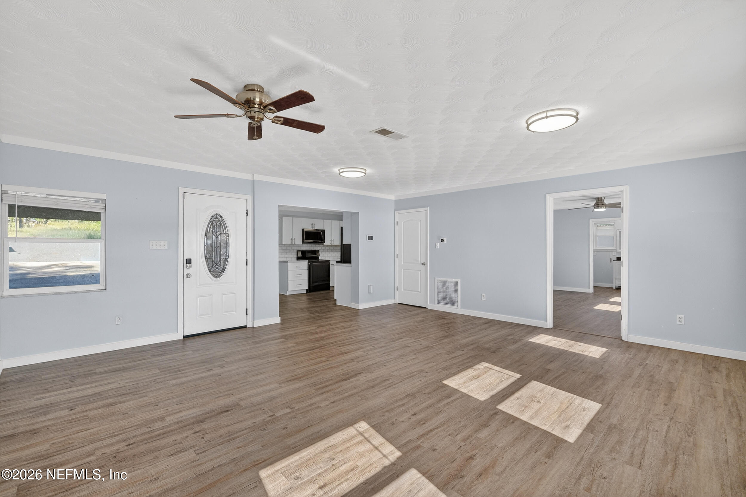 228 Southeast 66th Street Starke, FL 32091 - Photo 4 of 39 a view of empty room with wooden floor and ceiling fan