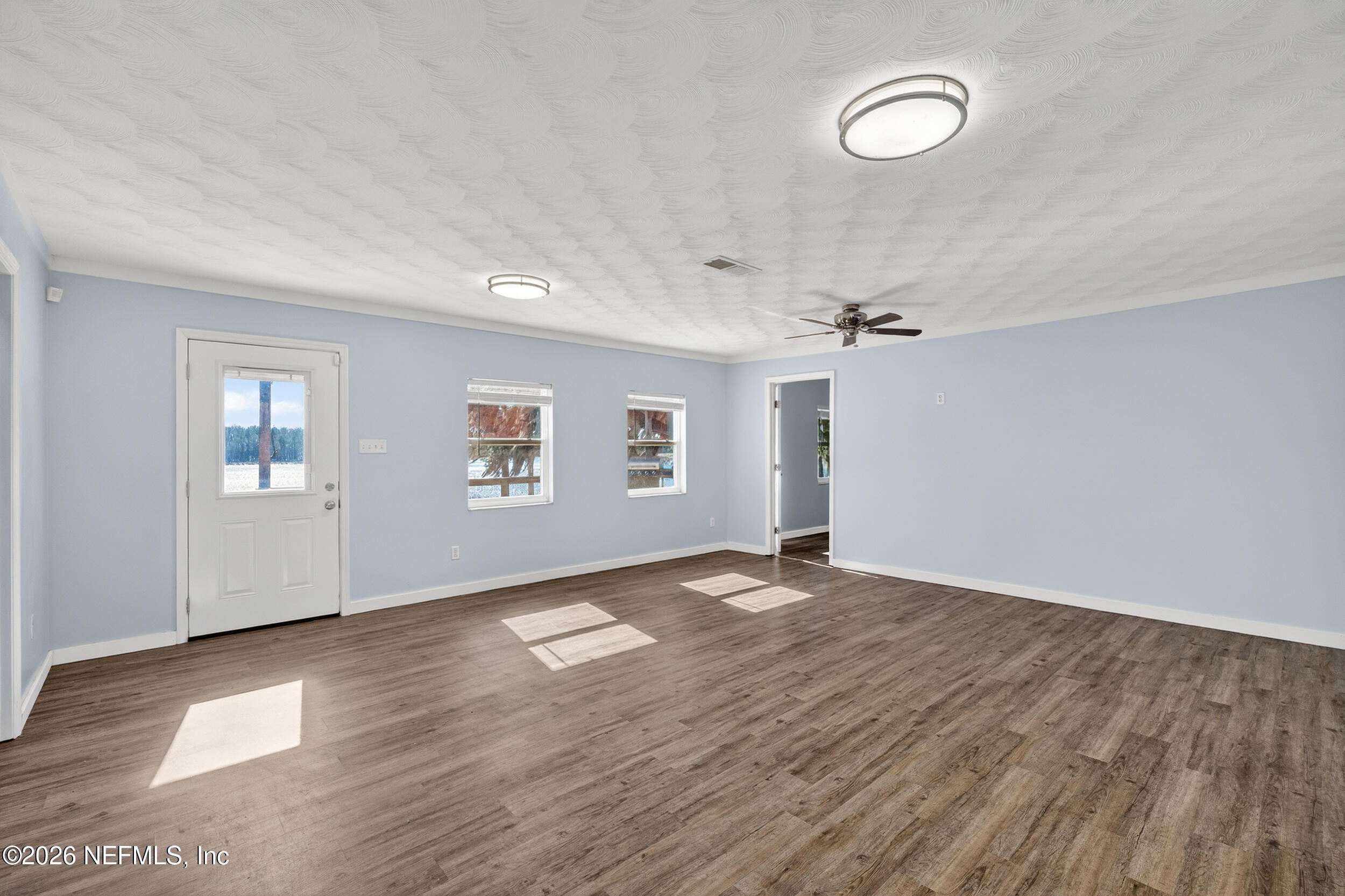 228 Southeast 66th Street Starke, FL 32091 - Photo 9 of 39 wooden floor in an empty room with a window