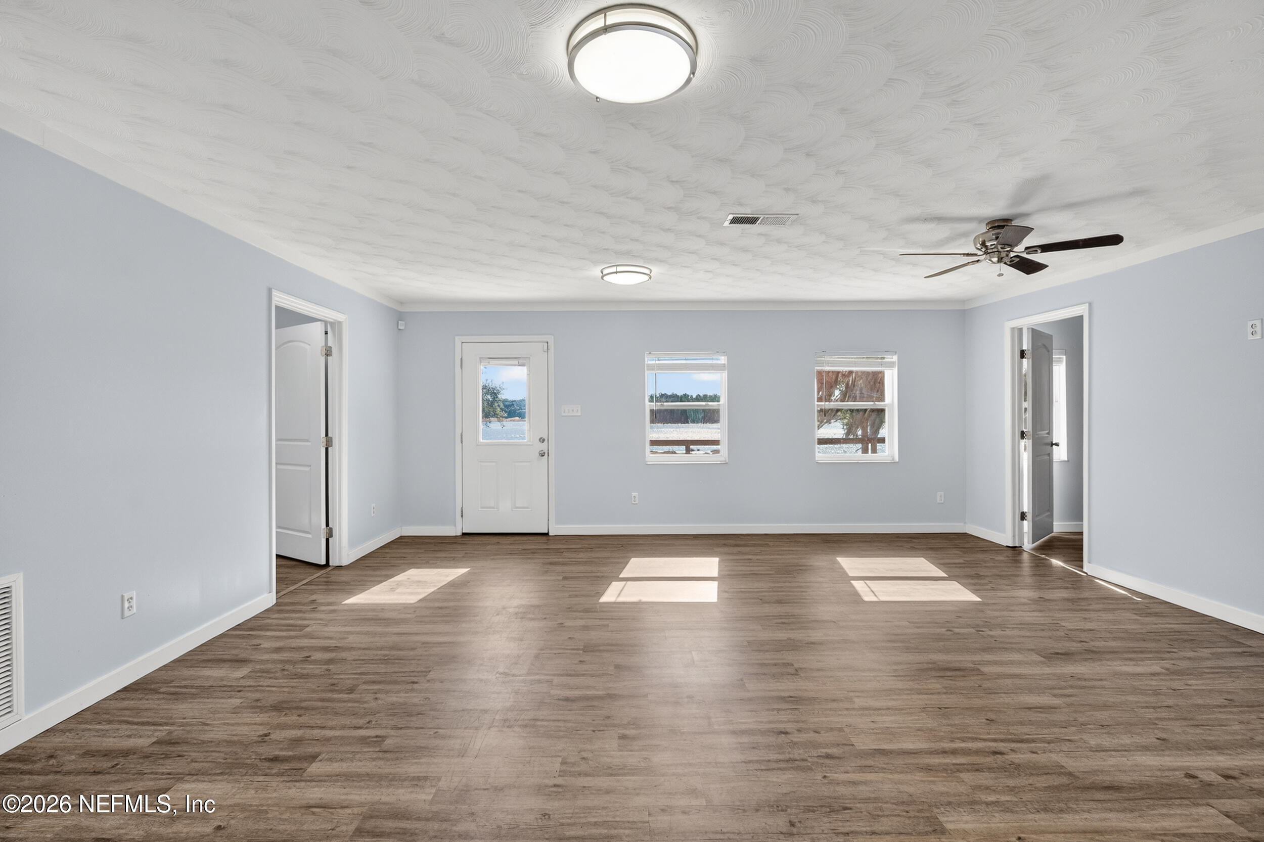 228 Southeast 66th Street Starke, FL 32091 - Photo 10 of 39 an empty room with wooden floor and windows