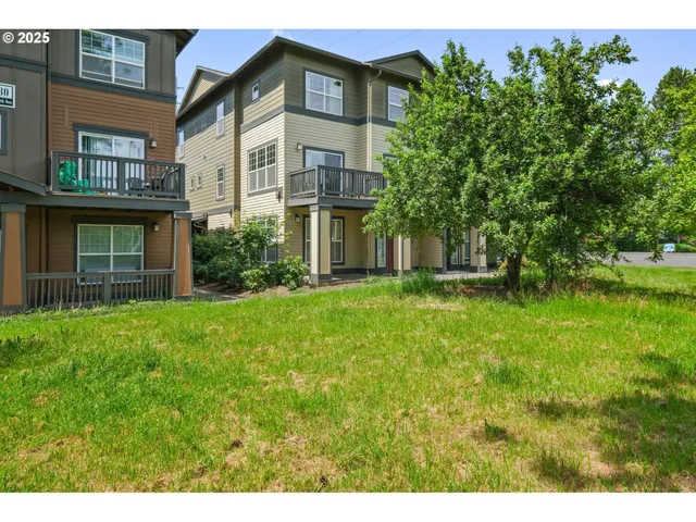a view of a house with brick walls and a yard with plants