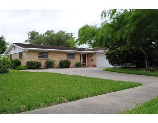 a front view of a house with a garden