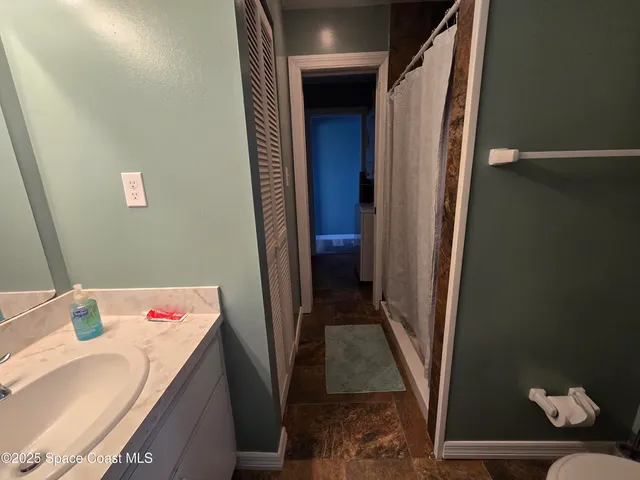 a kitchen with a sink a counter top space and living room area