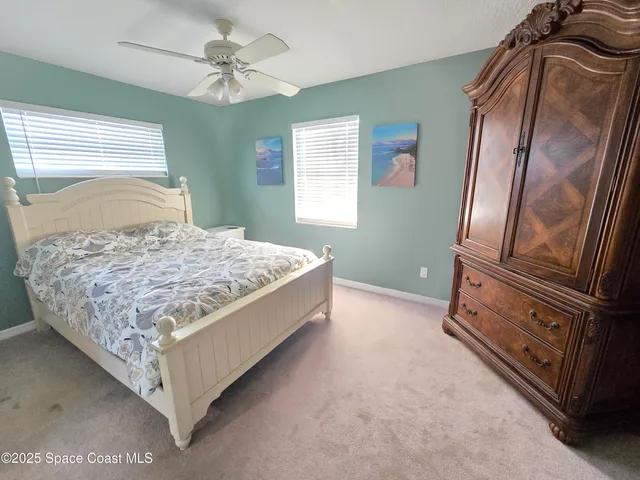 a large bedroom with a bed couch and window