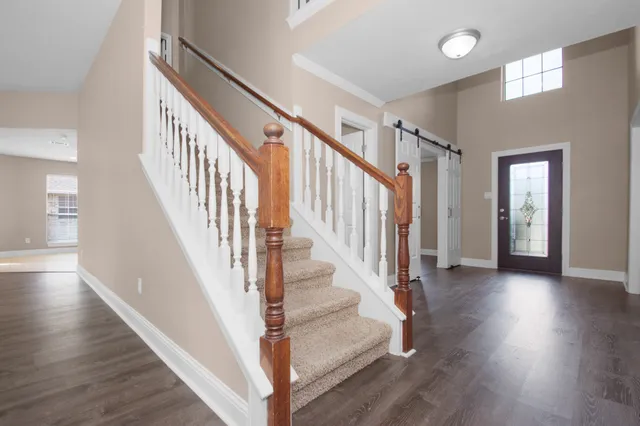 a view of staircase with wooden floor and a chandelier