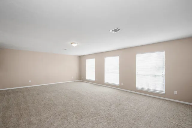 an empty room with windows and closet