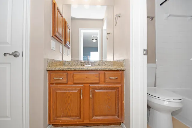 a bathroom with a granite countertop sink and a mirror