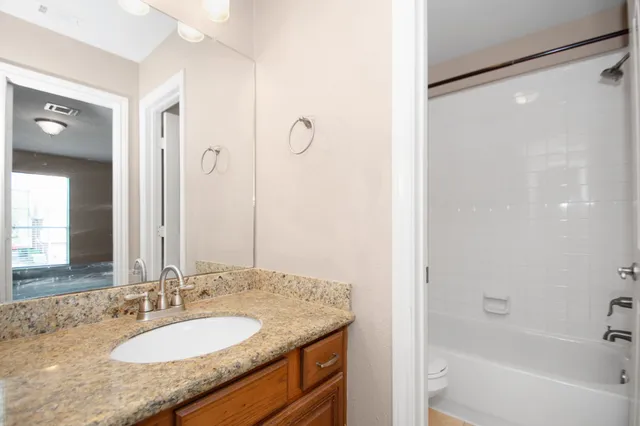 a bathroom with a granite countertop sink and a mirror