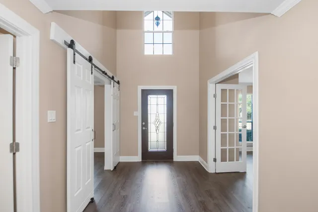 a view of a hallway with wooden floor and windows