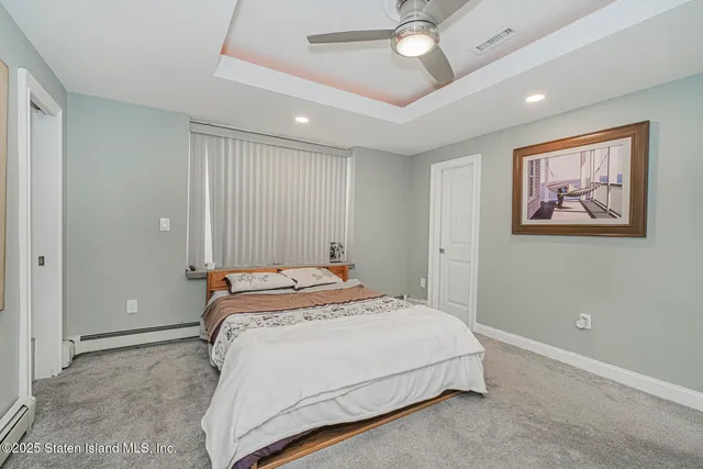 a spacious bedroom with a bed and a painting on the wall