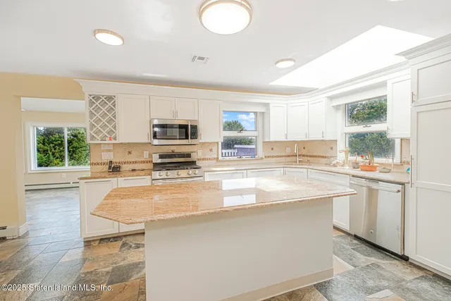 a kitchen with stainless steel appliances granite countertop a stove a sink and a microwave