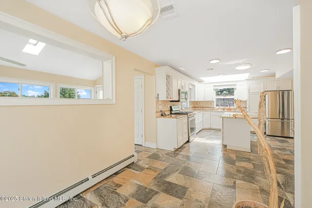 a kitchen with white cabinets and refrigerator