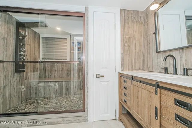 a bathroom with a shower sink and mirror