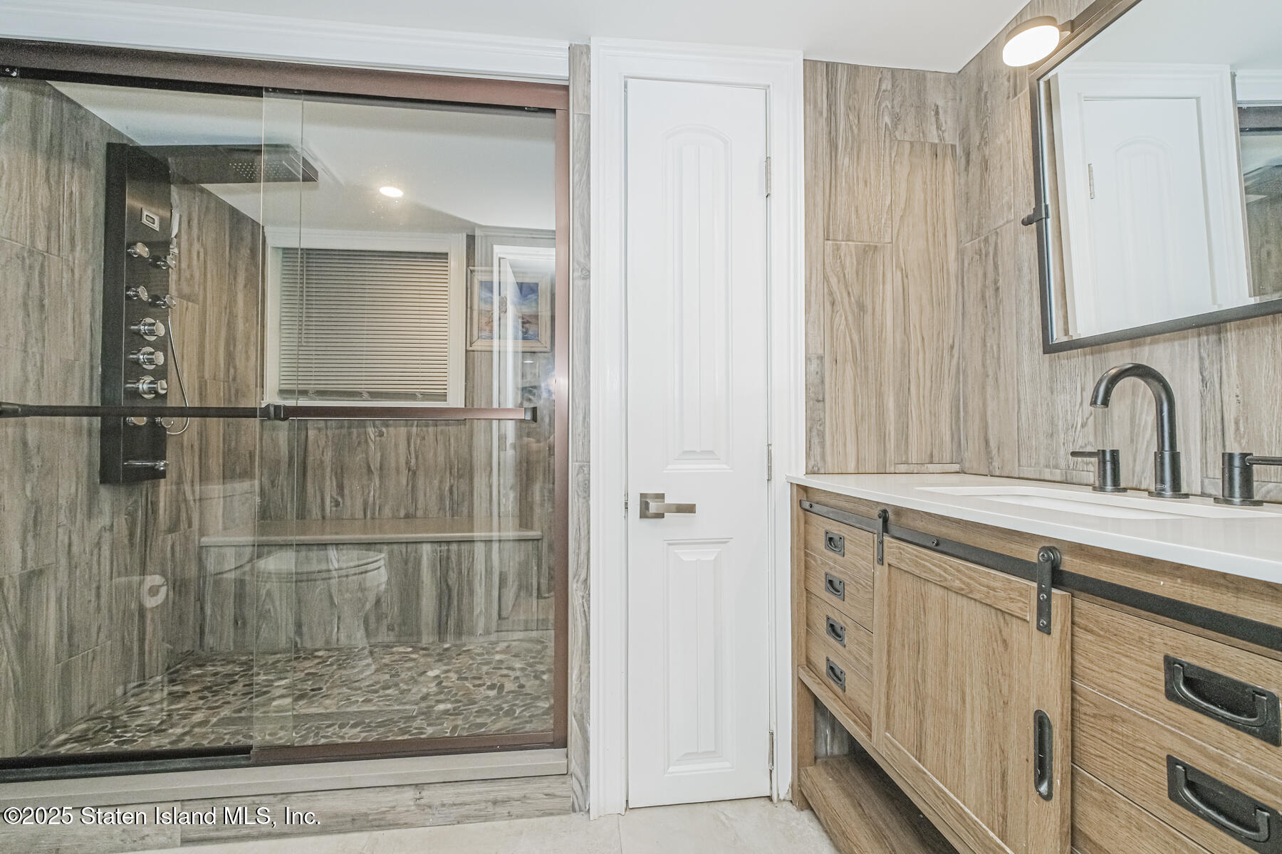 5434 Amboy Road Staten Island, NY 10312 - Photo 37 of 51 a bathroom with a shower sink and mirror