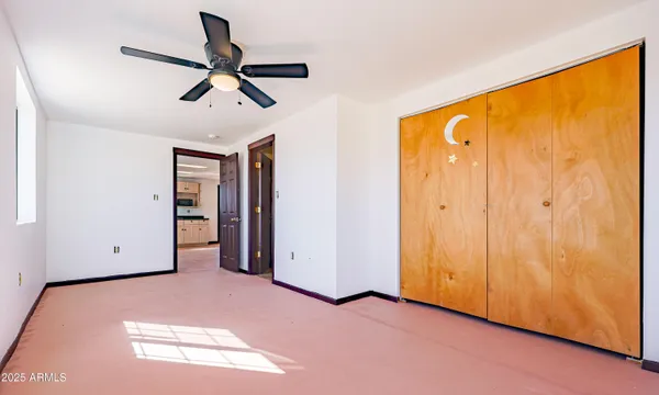 a view of a big room with windows and kitchen view