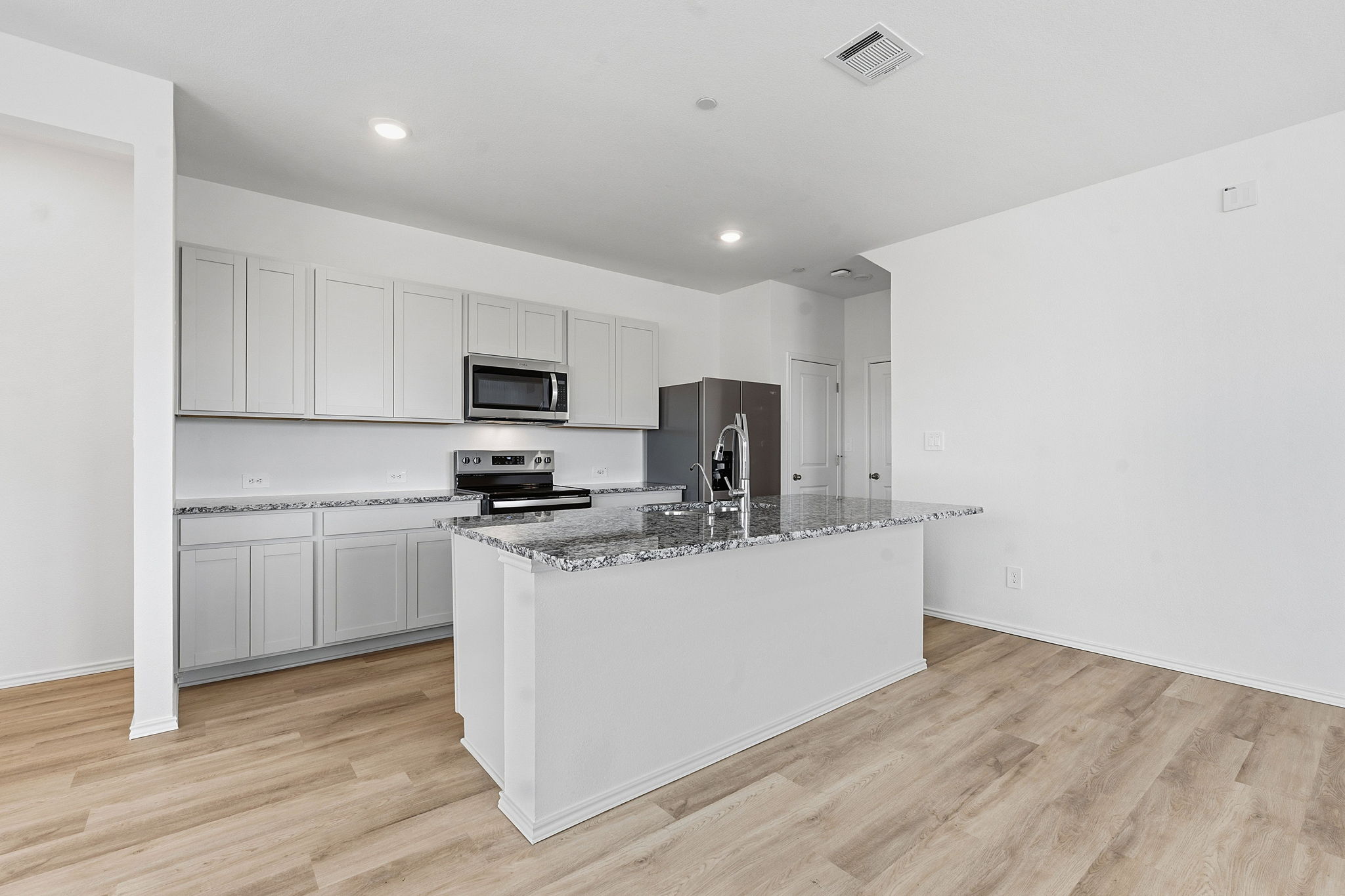 164 Cinnabar Lane, Unit 5 Kyle, TX 78640 - Photo 6 of 21 Kitchen featuring an expansive island with a breakfast bar, stainless steel appliances, light gray cabinetry, and stone countertops